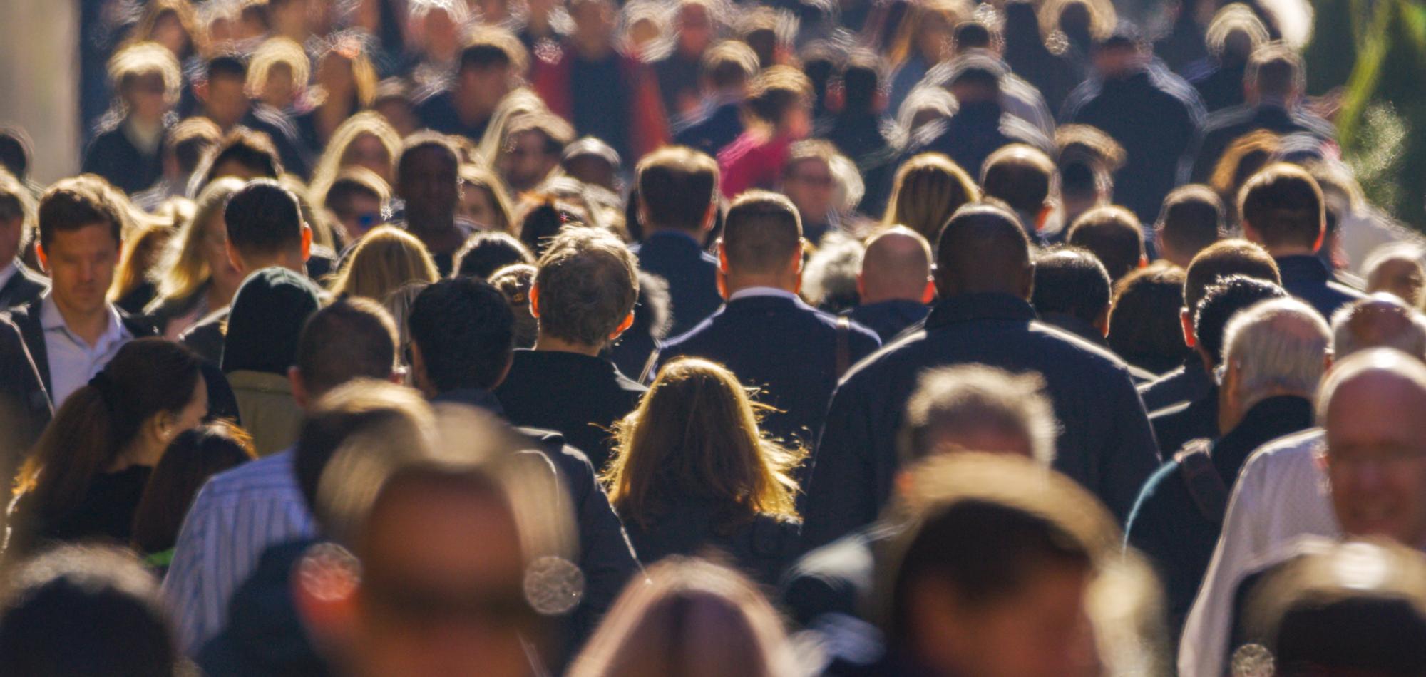 A busy crowd of people walking through a street