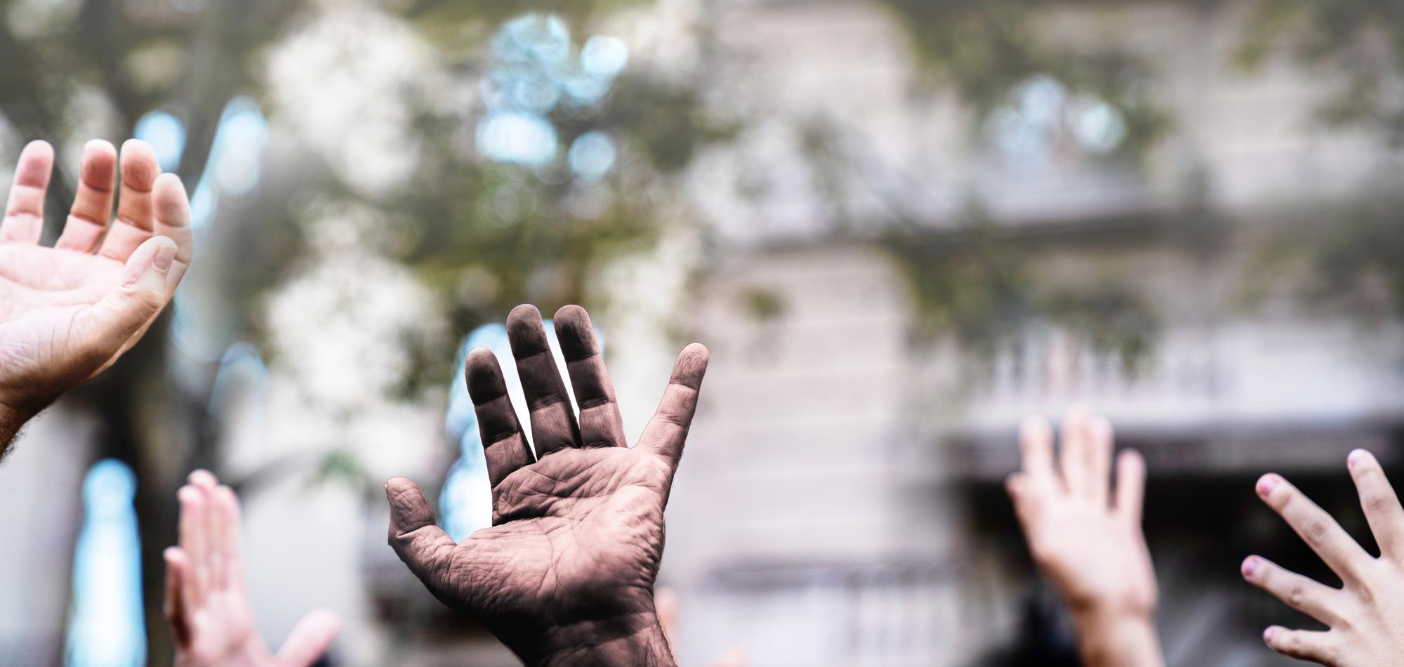 Diverse hands raised in the air