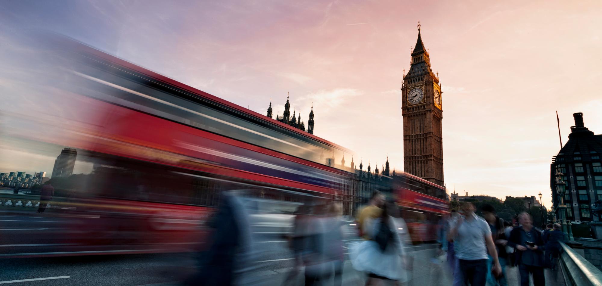 An image of Westminster with people and traffic moving past.
