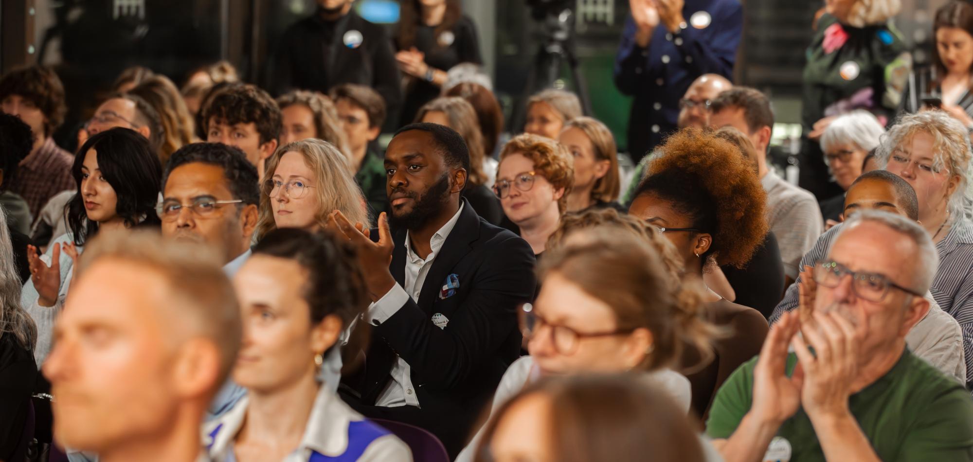 Attendees of Involve's 20th anniversary clapping