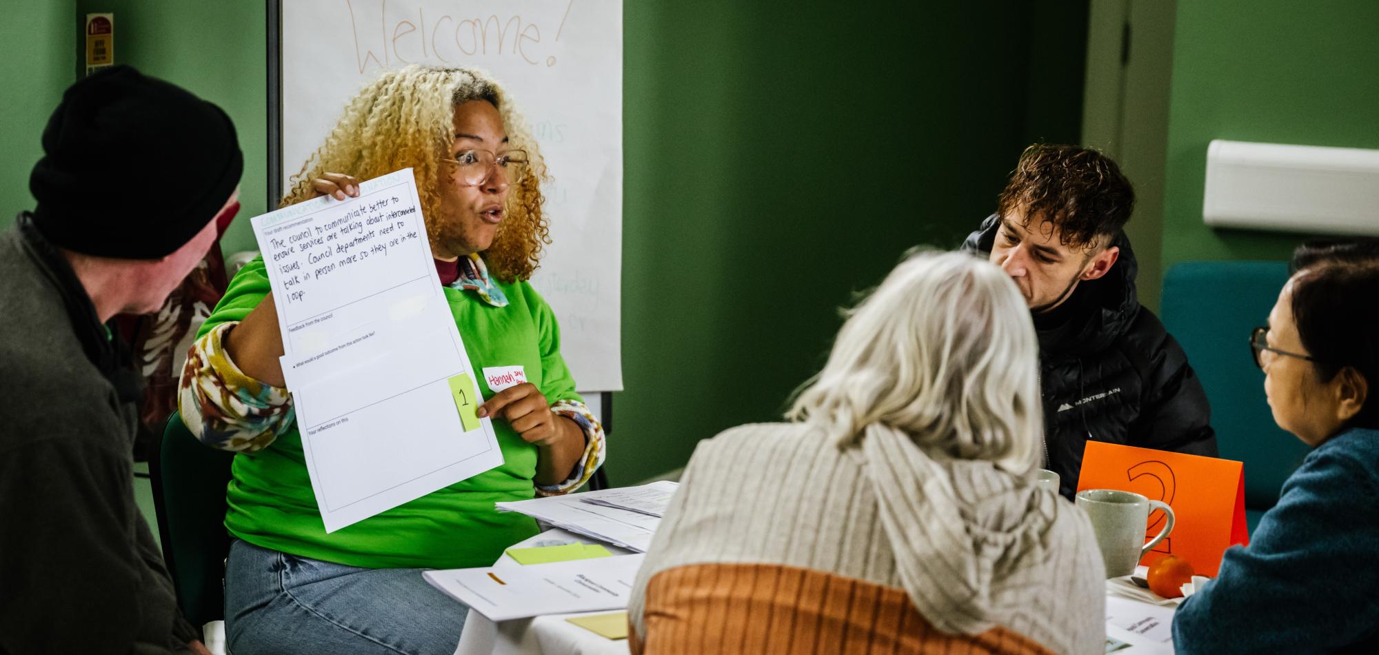 Participants engaged in a group discussion, looking at and reflecting on notes on a piece of paper