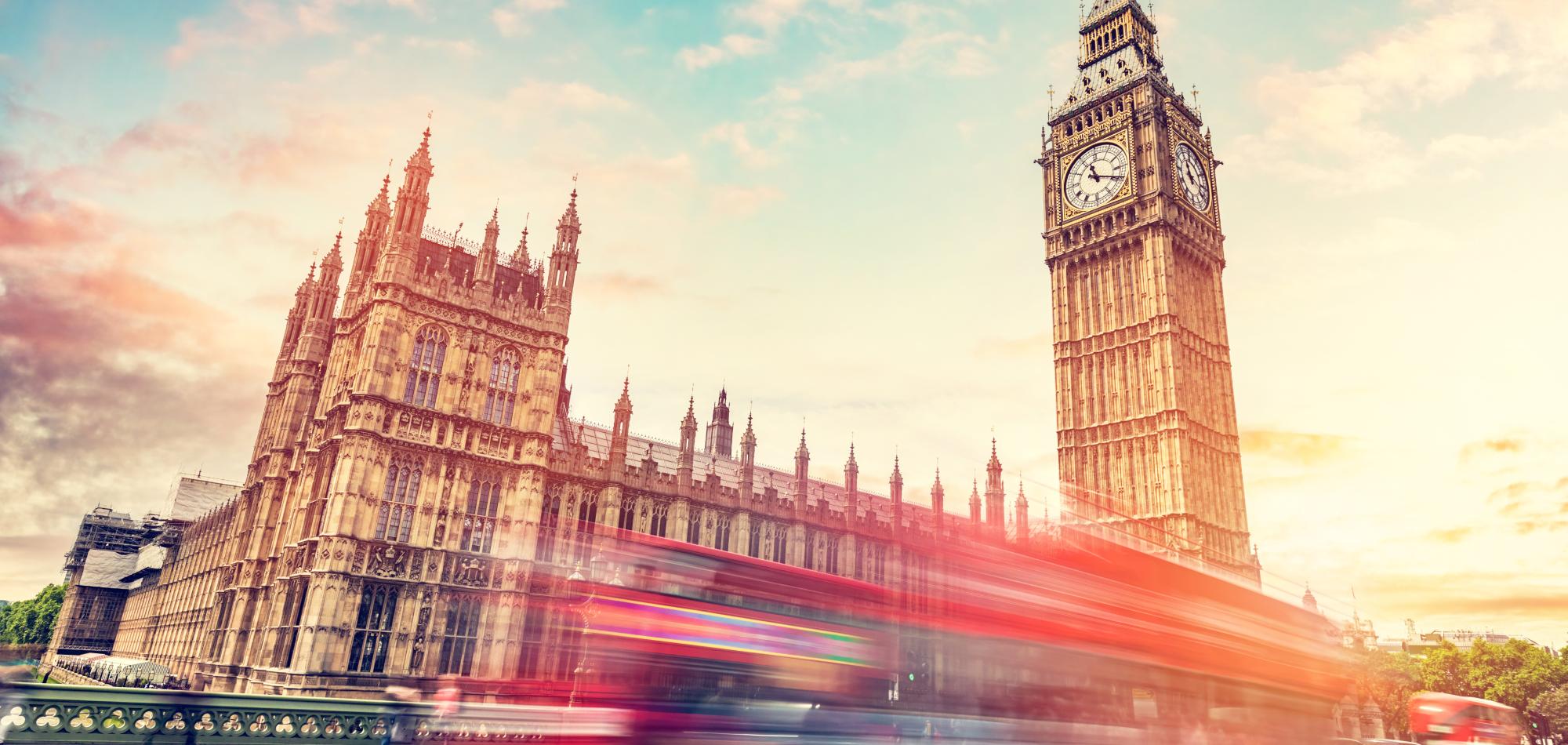 Photo of Westminster with a blurred red vehicle passing by