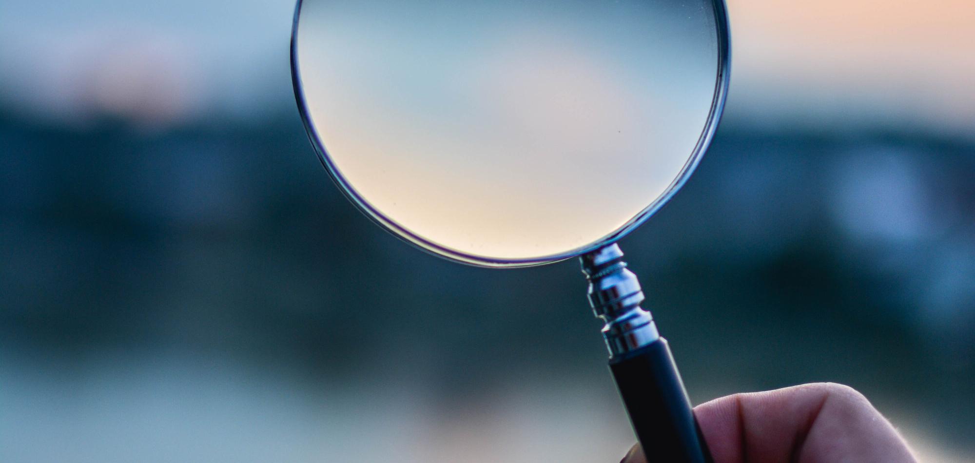 Magnifying glass, being held by someone. 