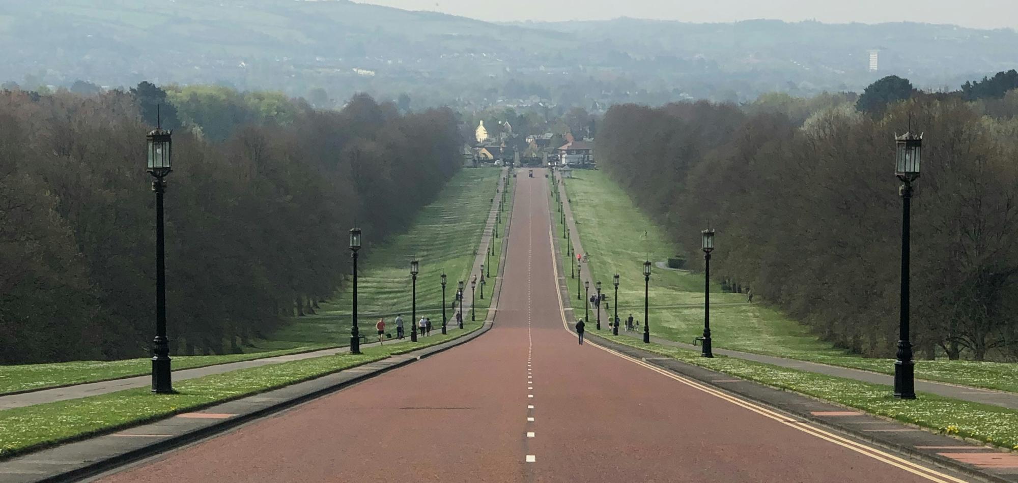Photograph of the road leading away from government buildings at Stormont downhill towards the city.