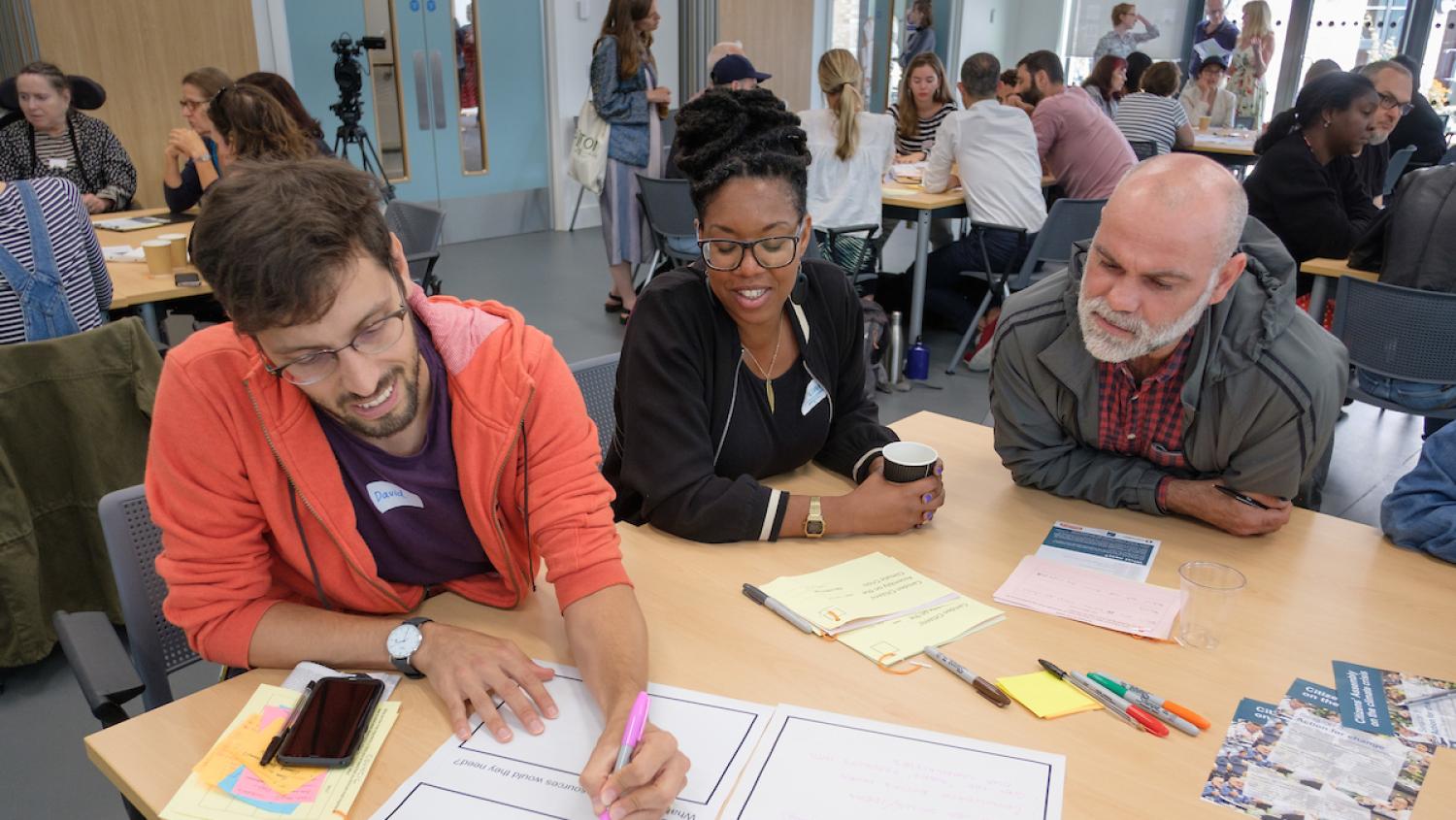 Citizen's Assembly members collaborating with filling in fact sheets