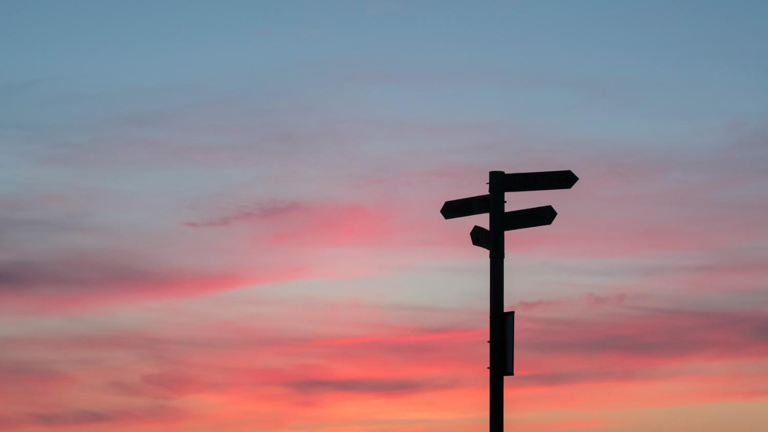 Sign post against a sunset background